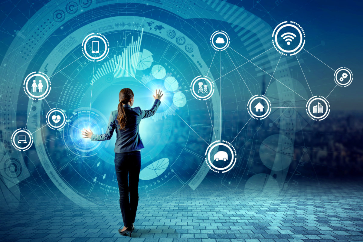  A businesswoman standing in front of a large digital screen with a network of icons representing digital transformation and automation in sales and marketing.